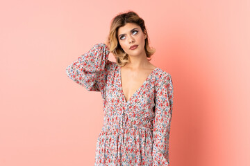 Obraz premium Young Russian woman isolated on pink background having doubts