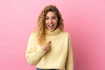 Young blonde woman isolated on pink background with surprise facial expression