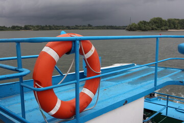 the deck of the ship boat with a lifebuoy for water floats on the river in a thunderstorm