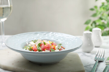 Delicious salad with watermelon, arugula and feta cheese served on white marble table