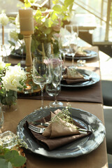 Festive table setting with beautiful tableware and floral decor in restaurant