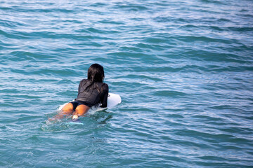 female surfer heading out to thee wavees