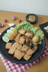 Fried chicken (ayam goreng) and tempeh (tempe) with bean sprouts (tauge) on a table 