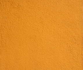 Fototapeta premium Orange background from rough textured plaster wall