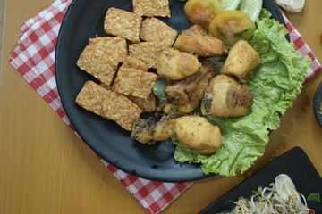 Fried chicken (ayam goreng) and tempeh (tempe) with bean sprouts (tauge) on a table 