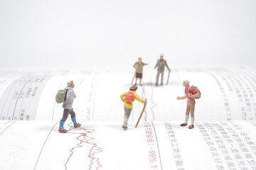 A Tiny figure of hiker walking on the open book