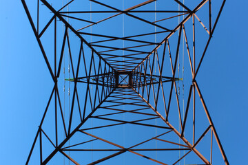 High voltage tower taken from downside or nadir with a blue sky  in the background 