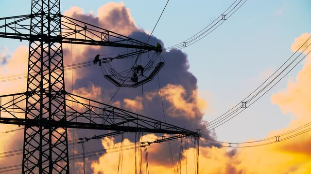 High-voltage pylon and power lines are maintained by technicians