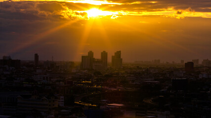 The blurred abstract background of the morning sun exposure to the tiny dust particles that surround the tall buildings in the capital, the long-term health issue of pollution.