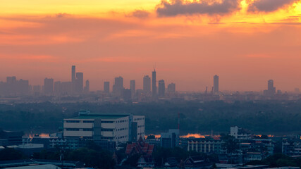 The blurred abstract background of the morning sun exposure to the tiny dust particles that surround the tall buildings in the capital, the long-term health issue of pollution.