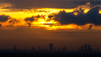 The blurred abstract background of the morning sun exposure to the tiny dust particles that surround the tall buildings in the capital, the long-term health issue of pollution.