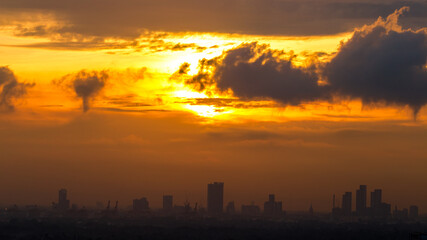 The blurred abstract background of the morning sun exposure to the tiny dust particles that surround the tall buildings in the capital, the long-term health issue of pollution.
