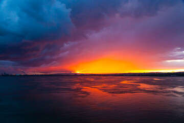 Fototapeta premium Sunset from the sea bay with red-orange-blue sky.