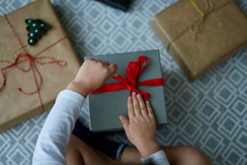 Girl opens Christmas gift. view from above. Christmas and New Year holidays.