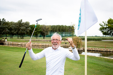 Portrait of an active senior man celebrating winning at the golf course and enjoying free time outdoors.