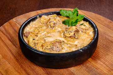 Pork with cream sauce in the pot