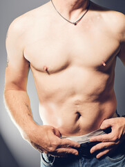 Naklejka premium Male shirtless upper body with hands in trowser