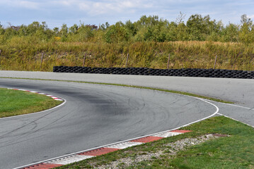 Shot of empty auto racing racetrack turn. Motor racing track. Turning asphalt road with marking lines - obrazy, fototapety, plakaty