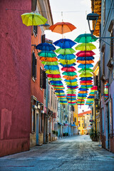 Fototapeta na wymiar Street in Novigrad decorated with umbrellas