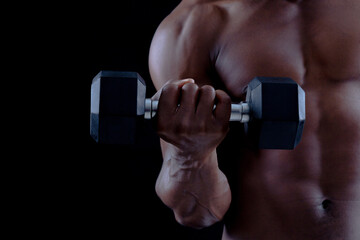 Fototapeta na wymiar Healthy young african man exercising with dumbbell. Bodybuilder training on a bllack background.