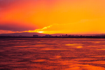 Sunset from the sea bay with a red-orange sky. Colorful sky at sunset Sea bay in the Canadian city of Quebec at a picturesque sunset.