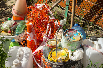 Waste post repair and painting garbage plastic and residues of chemicals lie on the grass,...