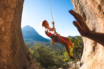 The rock climber gives a high five to his partner