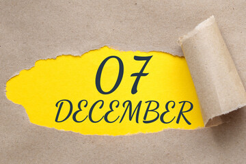 december 07. 07th day of the month, calendar date.Hole in paper with edges torn off. Yellow background is visible through ragged hole.Winter month, day of the year concept