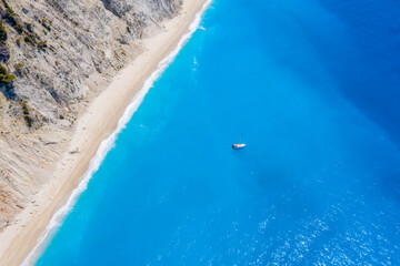 Lefkada, Greece. Remote white Egremni beach with lonely luxury yacht boat on the turquoise colored bay on Ionian Sea