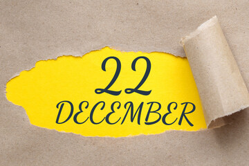 december 22. 22th day of the month, calendar date.Hole in paper with edges torn off. Yellow background is visible through ragged hole.Winter month, day of the year concept