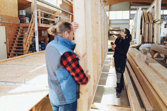 Female Carpenter Or Woodworker Inspecting A Prefabricated Wall