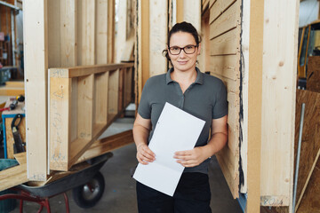 Employee in a woodworking factory between prefabricated walls