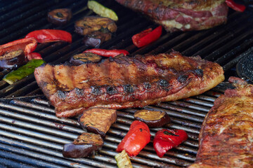 Large cuts of grilled meat with vegetables