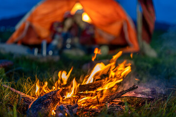 The warmth of the fire from the campfire as people camp to relax and enjoy nature on vacation.