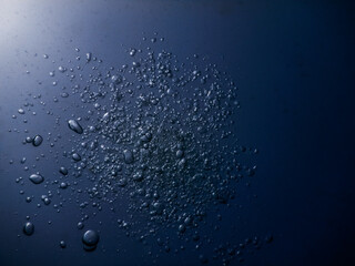 lot of little bubbles in dark blue water while diving in a lake