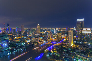 Fototapeta na wymiar Aerial view night time lapse of landmark financial district and business center with skyscraper over Chao Phraya River at Bangkok, Thailand.