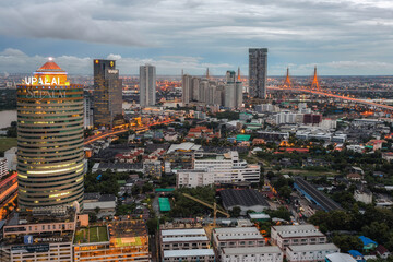 Aerial view night time lapse of landmark financial district and business center with skyscraper over Chao Phraya River at Bangkok, Thailand.
