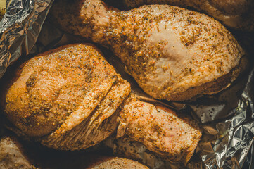 Pickled chicken legs in foil for baking. Cooking in the oven. Close-up, selective focus