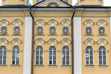 Fragment of the facade of the palace with windows and a yellow wall