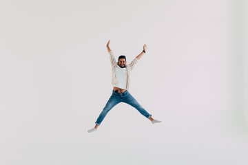 Handsome indian man jumping isolated on white background