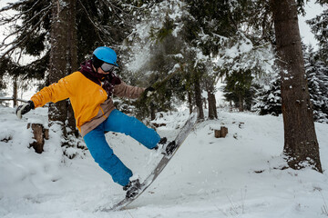 Fototapeta na wymiar Adventure to winter sport. Snowboarder man hiking at mountain. Looking for powder to freeride