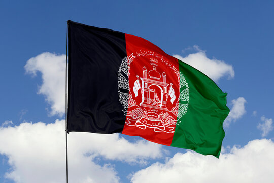 Afghanistan flag isolated on the blue sky background. close up waving flag of Afghanistan. flag symbols of Afghanistan. Concept of Afghanistan.