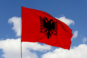 Albania flag isolated on the blue sky background. close up waving flag of Albania. flag symbols of Albania. Concept of Albania.
