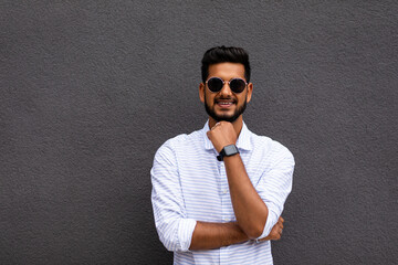 Fototapeta premium Portrait of a young business man smiling against gray background