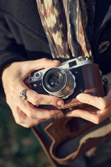 Obraz premium 40's old elegant lady using vintage photo camera in the park