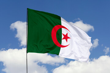 Algeria flag isolated on the blue sky background. close up waving flag of Algeria. flag symbols of Algeria. Concept of Algeria.