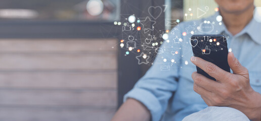 Man using mobile phone at home with social media apps icons on virtual screen, social media, digital marketing