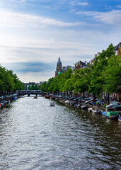 Typical Amsterdam canals with bridges and colorful boat, Netherlands, Europe