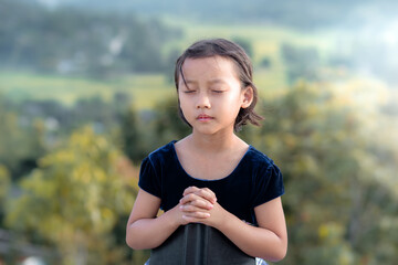 Cute asian little girl praying, christian concept.