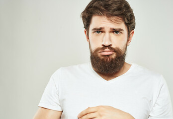 Obraz premium emotional man in a white t-shirt irritated facial expression close-up